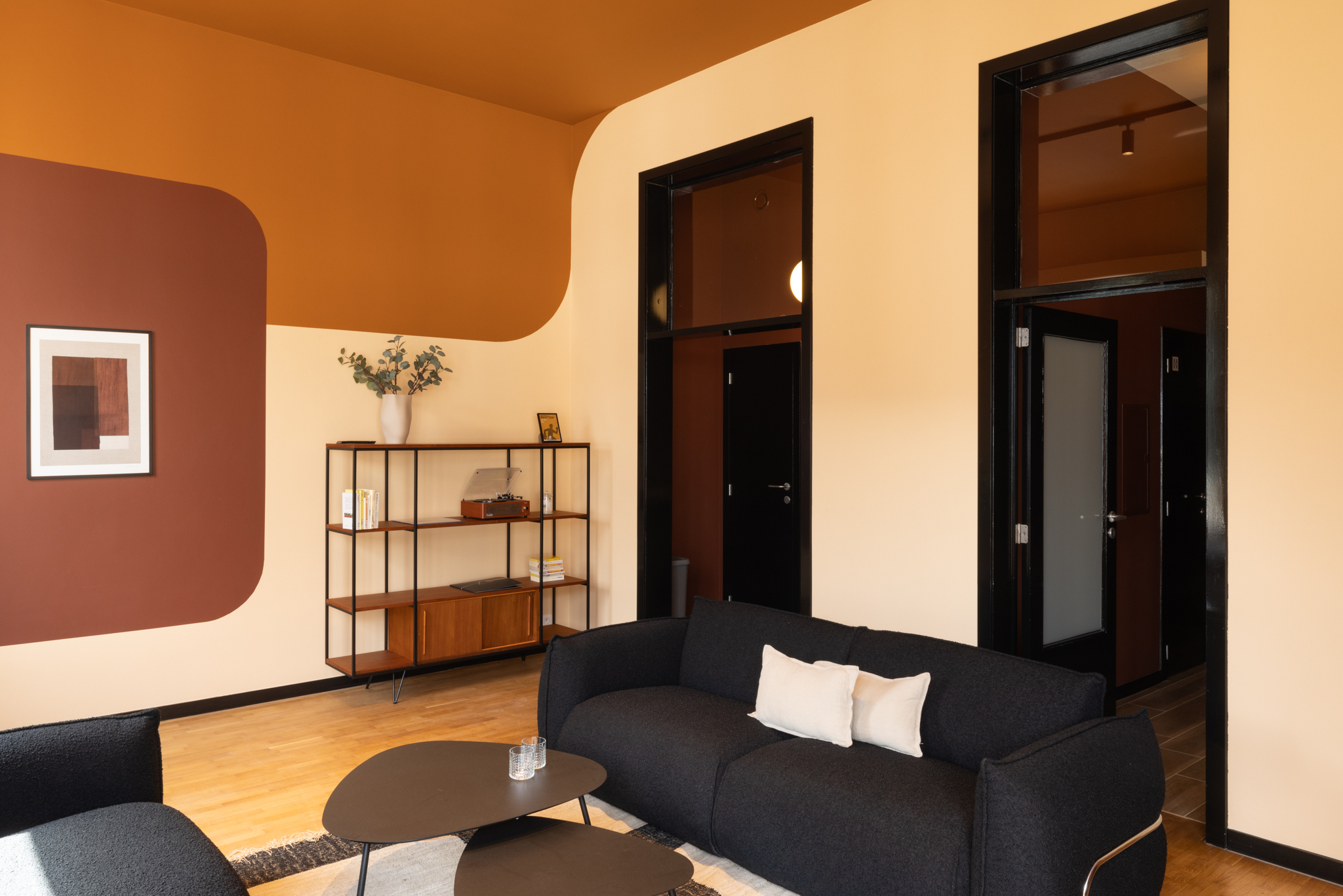 rénovation Co living, ambiance coloré, teinte cognac, dessins murales courbes