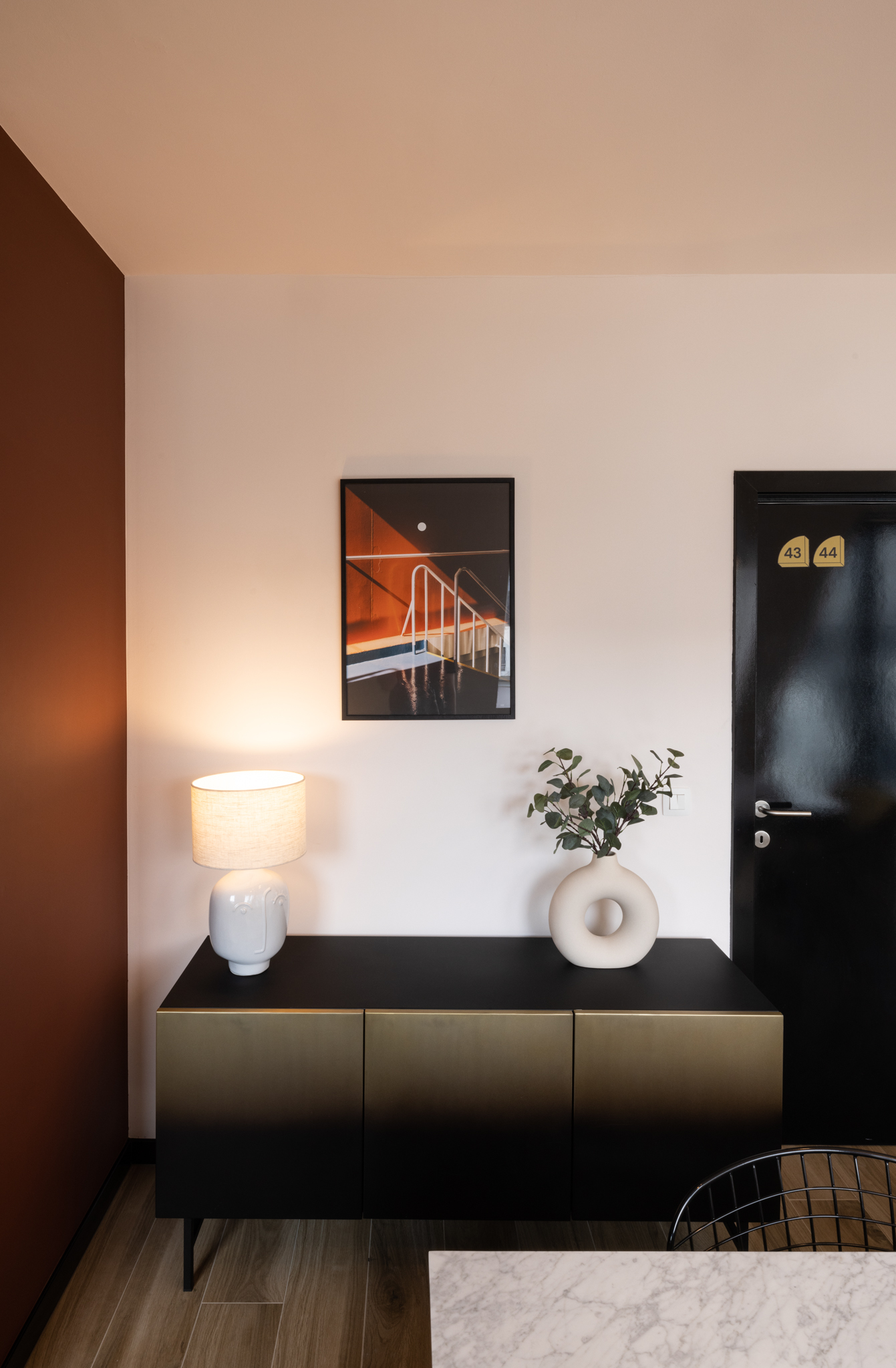 salle à manger terracotta, meuble dorée, porte noire brillant