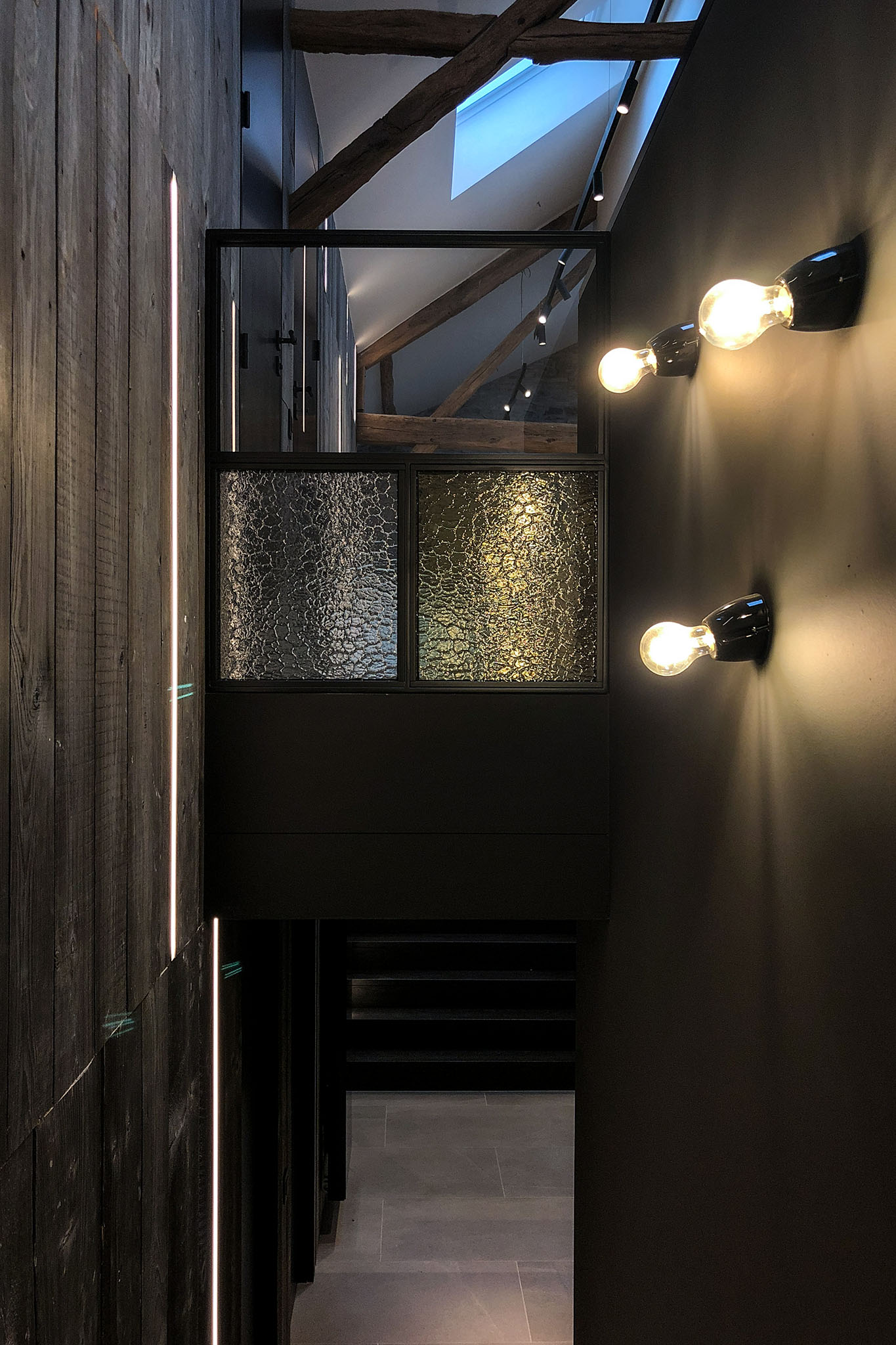 Hall central neuf mètres de haut dans ancienne grange rénovée, ambiance sombre