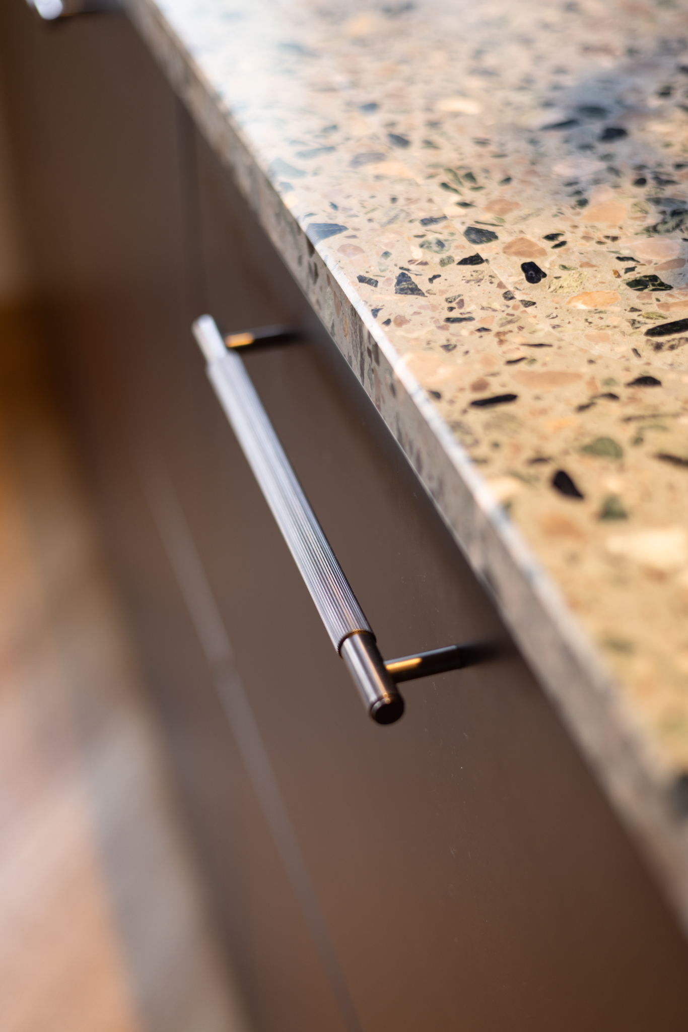 Plan de travail terrazzo vert et détail de poigné en gun metal