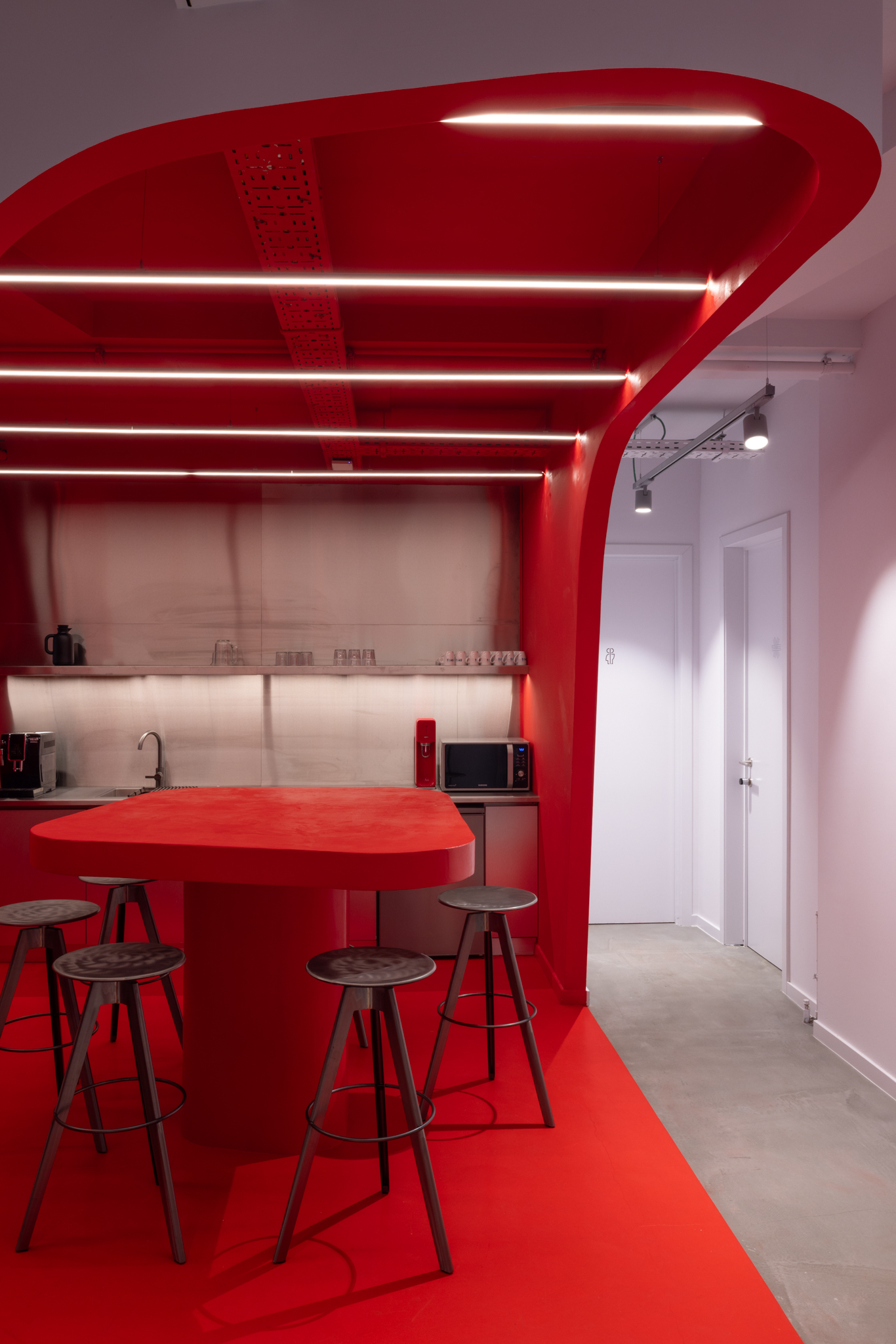 Cuisine inox et table organique dans un centre AI inspiré du spatial