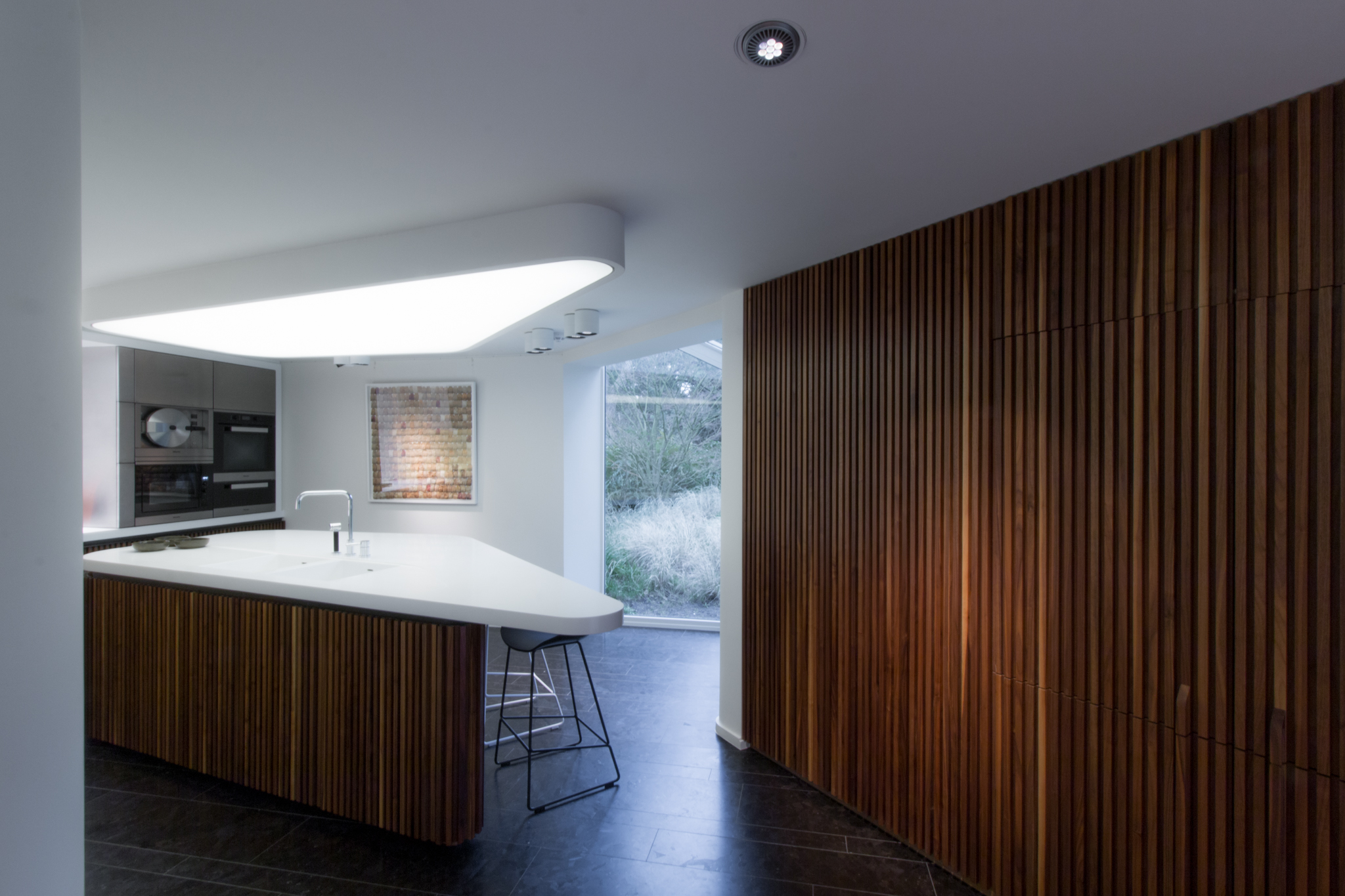 Cuisine moderne bois et Corian avec îlot triangulaire à Knokke, lambris bois