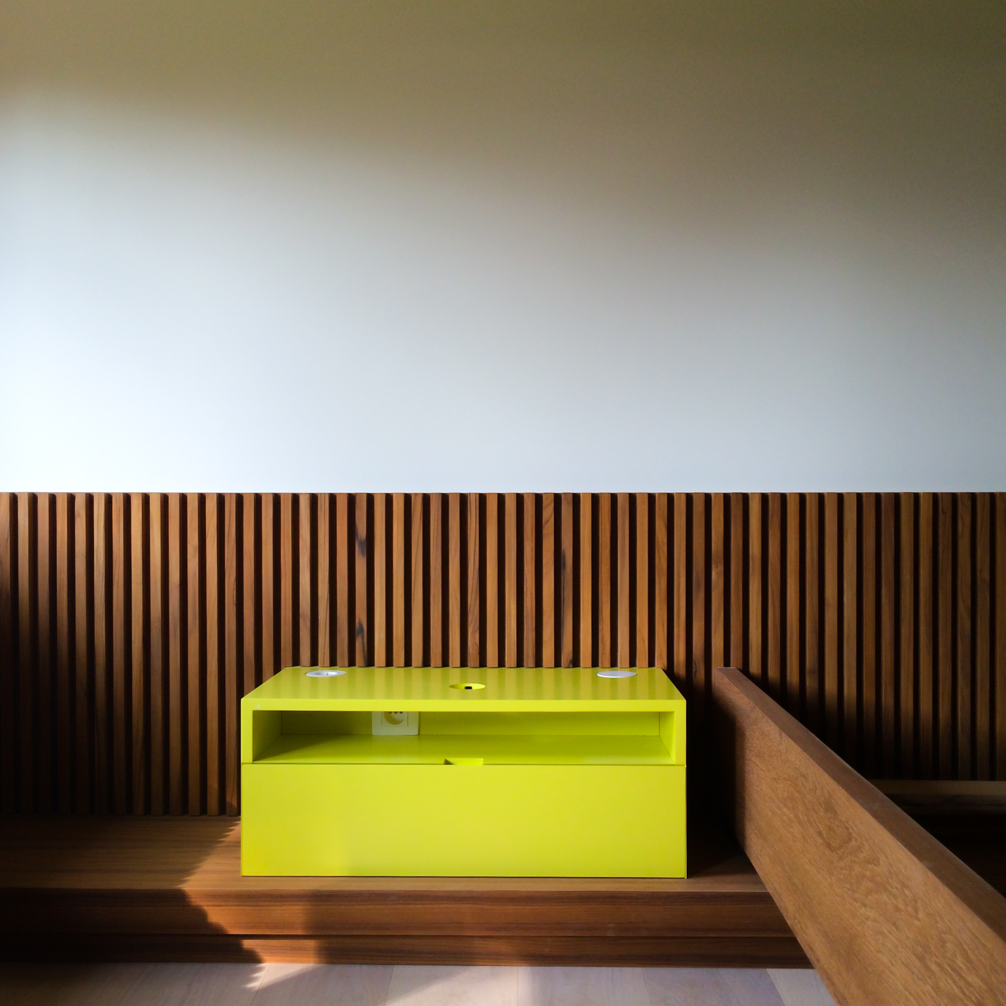 table de nuit jaune vif et tête de lit en lattis bois