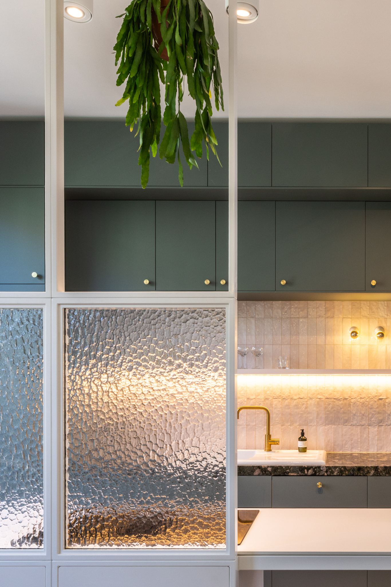 cuisine vert pâle, crédence rose, îlot ferronnerie blanc sur mesure, verre texturé, évier en porcelaine