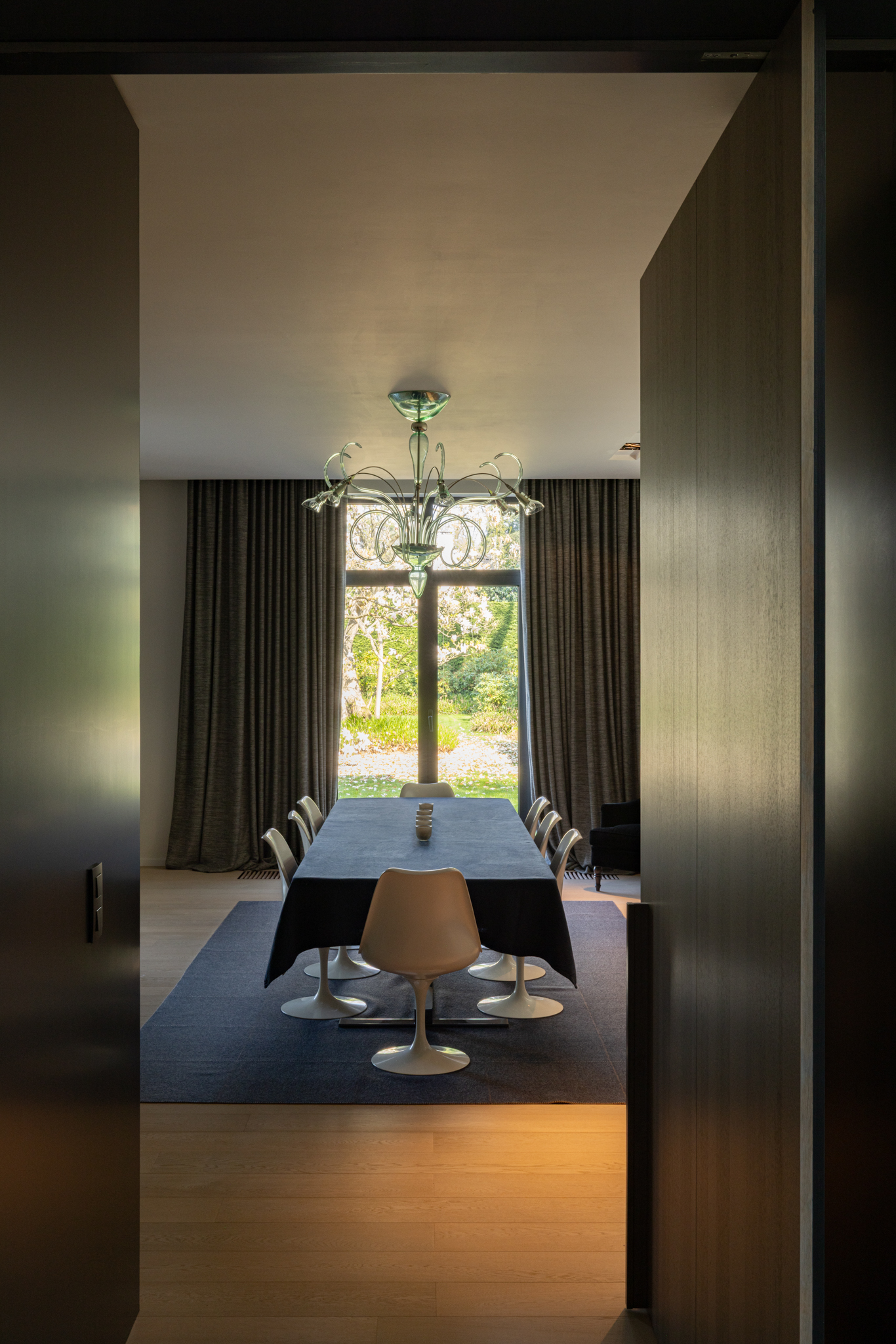 Salle à manger baignée de lumière naturelle, avec baie vitrée encadrant un magnolia majestueux