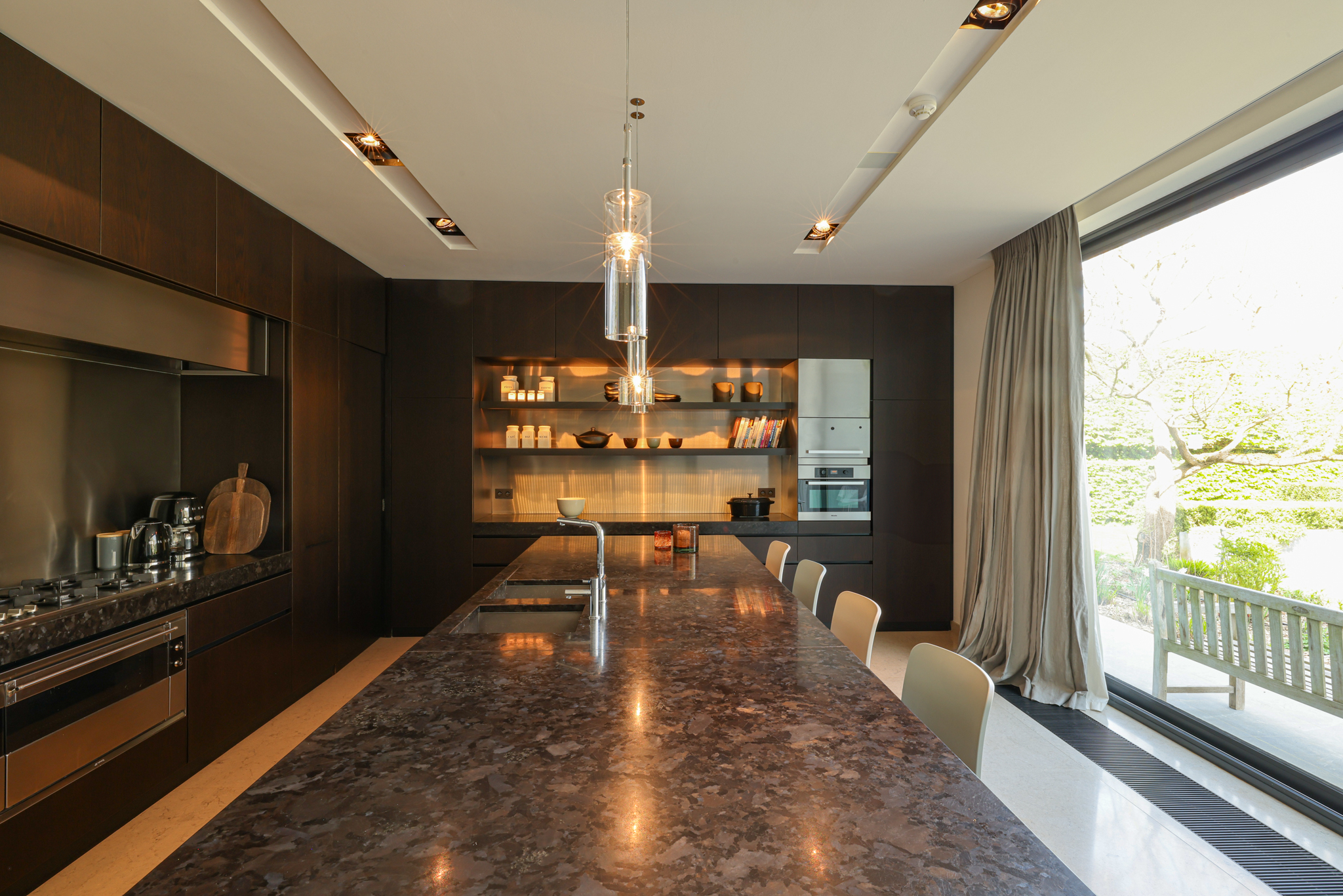 Cuisine haut de gamme en granit noir, intégrée dans l’annexe contemporaine de la villa