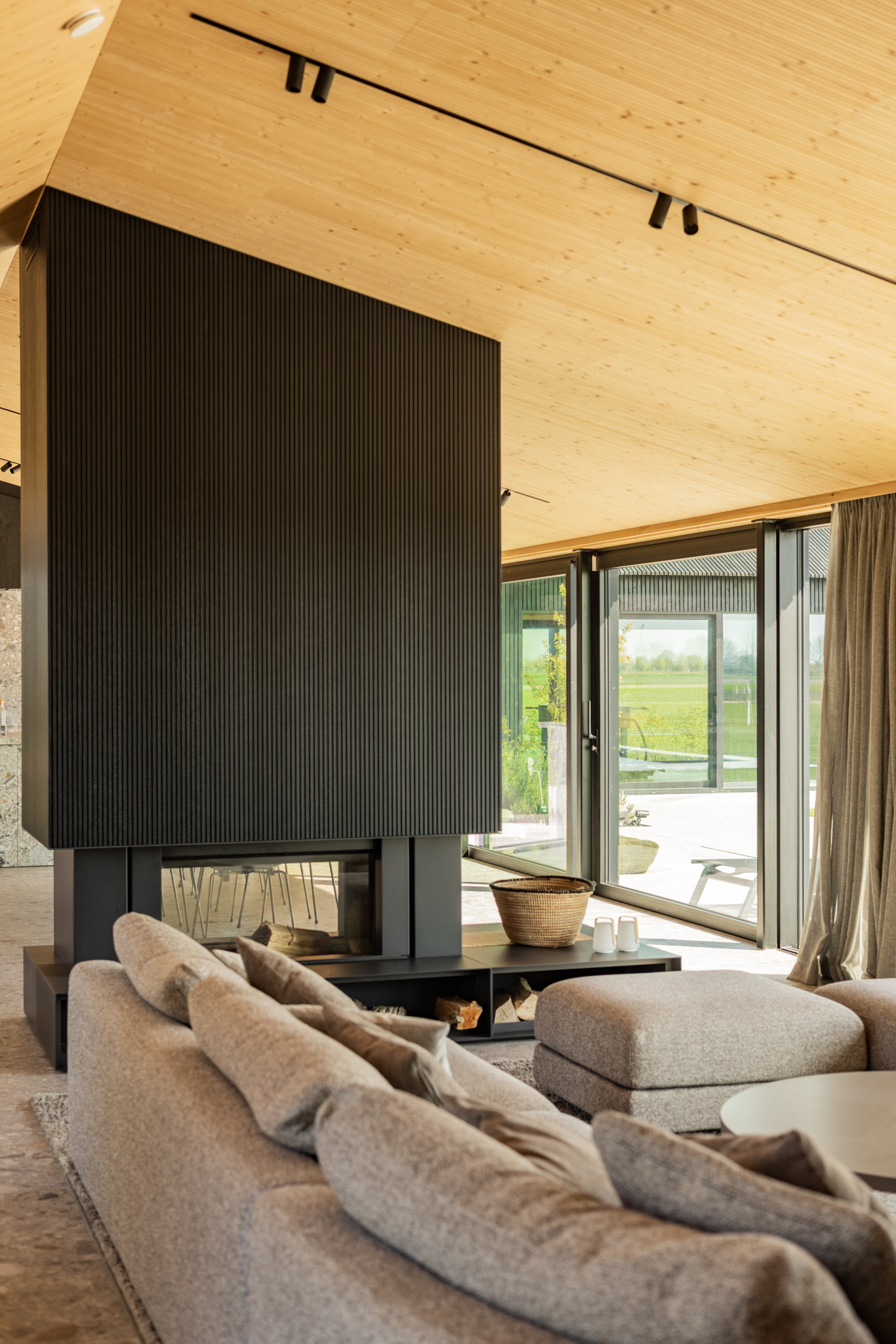 Teintes et matériaux harmonisés entre façade et intérieur bois, cheminé architecturale